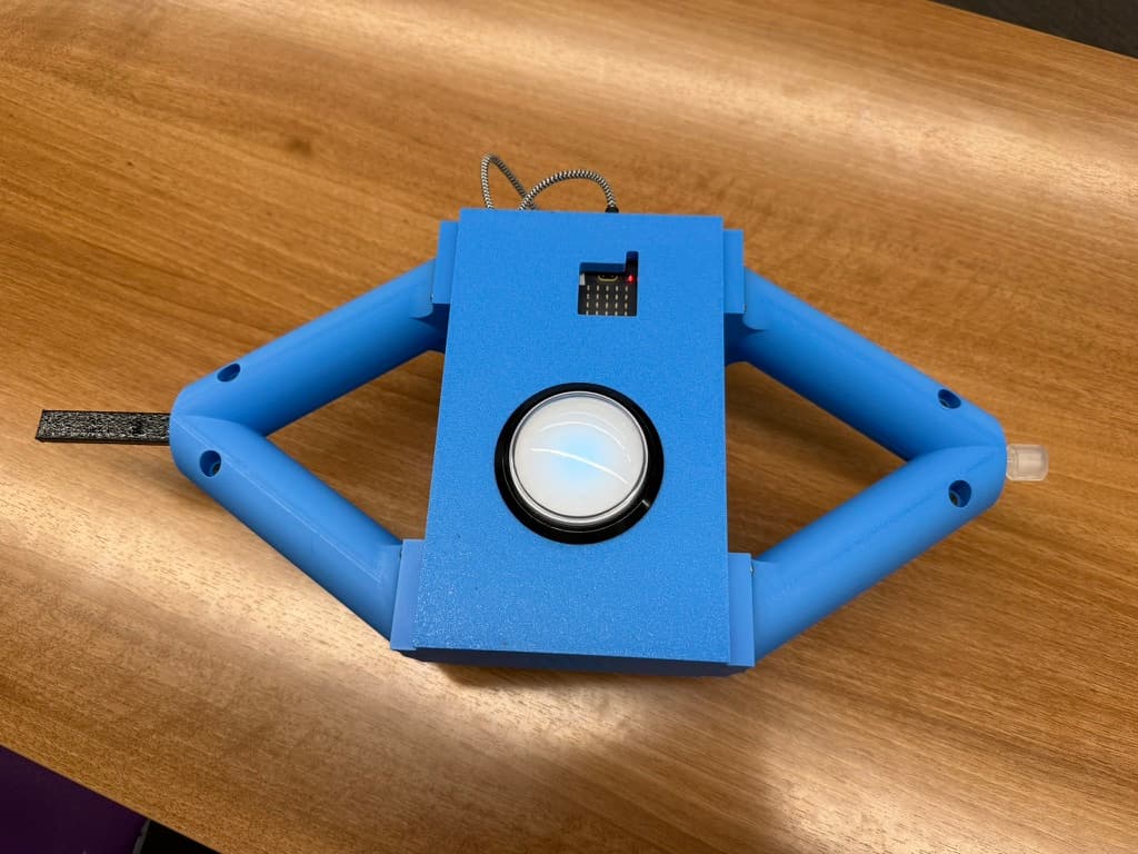 Front view of the completed blue DIY Bop It game with a large arcade button, flex sensor, rotary control, and 3D-printed enclosure