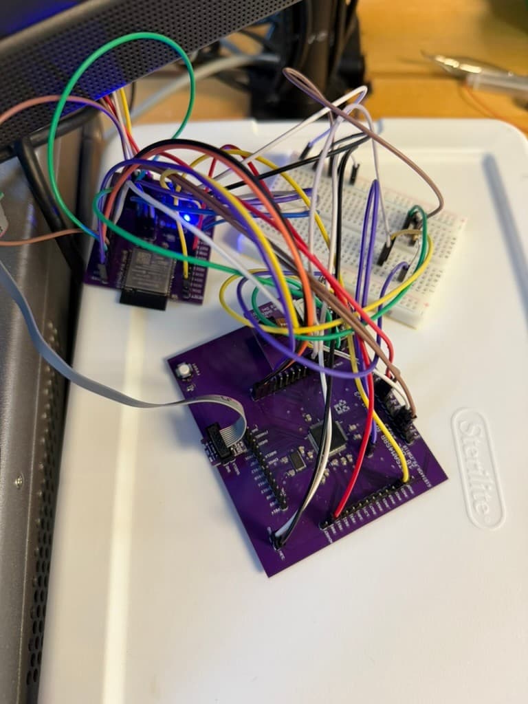 Integrated embedded webcam prototype with purple PCB, ESP32 module, breadboard circuitry, and jumper wiring