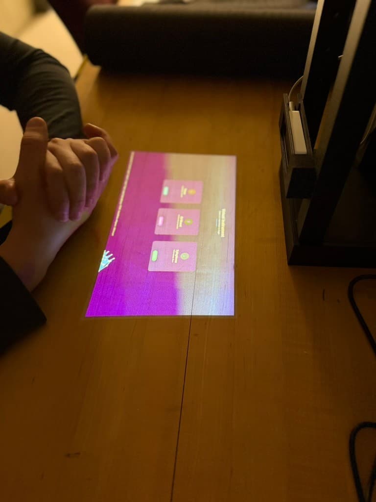 A user holding a hand above the projected Portable Piano instrument-selection menu