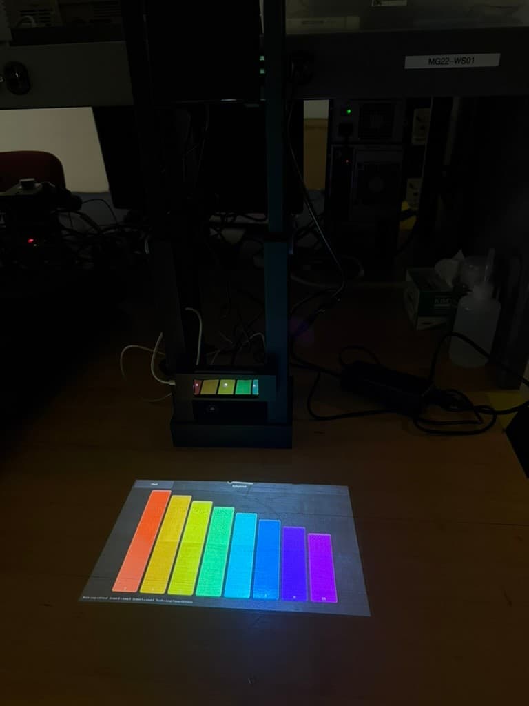 Portable Piano system projecting its eight-note rainbow xylophone interface onto a table